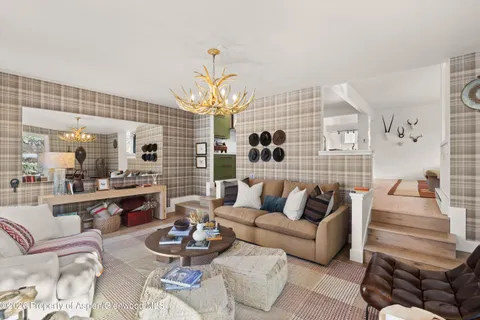 a living room with furniture and a chandelier