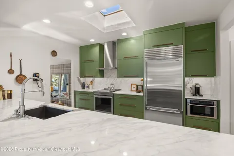 a large kitchen with stainless steel appliances kitchen island a sink dishwasher a stove and refrigerator