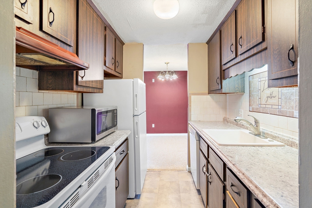 35 High Street, Unit 9 Marlborough, MA 01752 - Photo 11 of 25 a kitchen with granite countertop a sink stove and refrigerator
