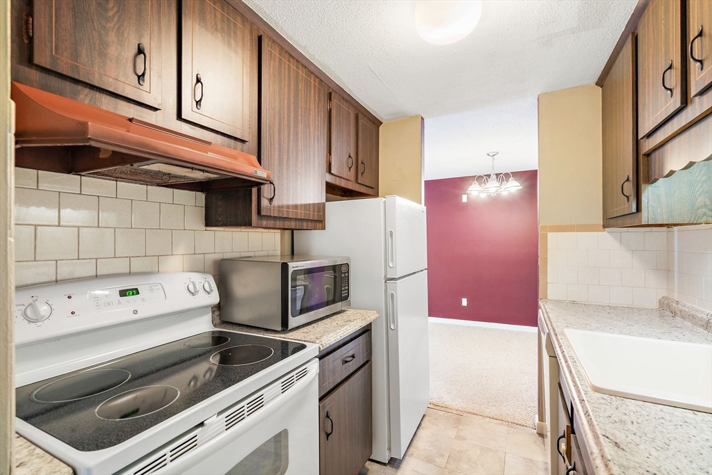 35 High Street, Unit 9 Marlborough, MA 01752 - Photo 12 of 25 a kitchen with a stove cabinets and a refrigerator