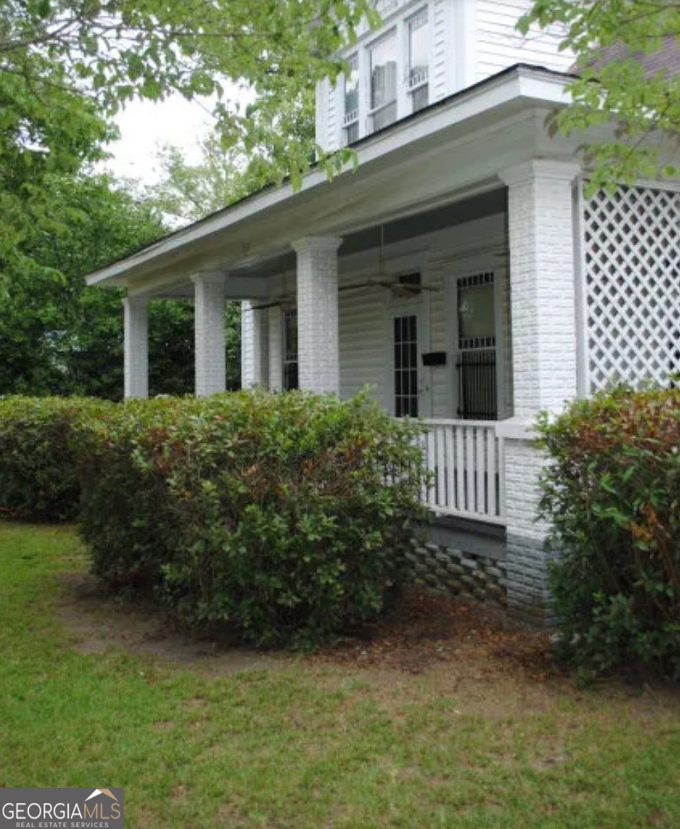 516 West Altamaha Street Fitzgerald, GA 31750 - Photo 3 of 17 a view of a house with a small yard plants and large trees
