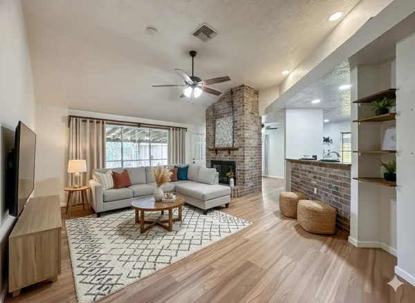 a living room with furniture a flat screen tv and a fireplace