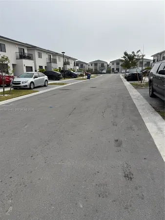a view of parking with cars parked on road