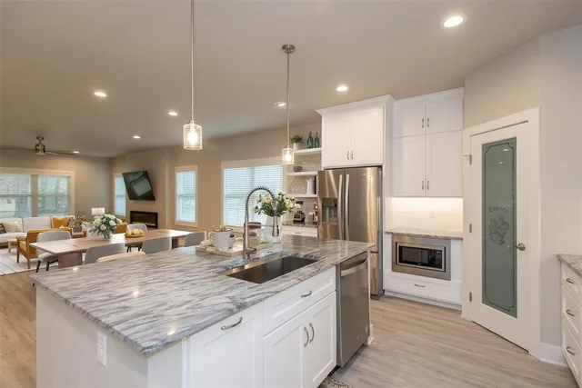 a kitchen with stainless steel appliances granite countertop a sink stove and refrigerator