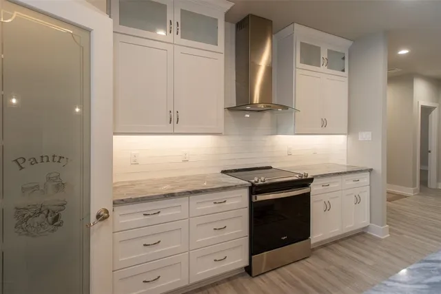 a kitchen with granite countertop white cabinets and white appliances