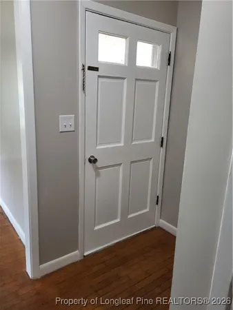 an empty room with wooden floor and a window