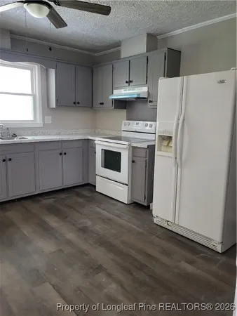 a kitchen with cabinets appliances a sink and a window