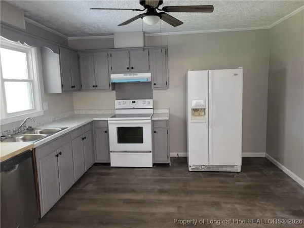 a kitchen with stainless steel appliances a stove a sink and white cabinets