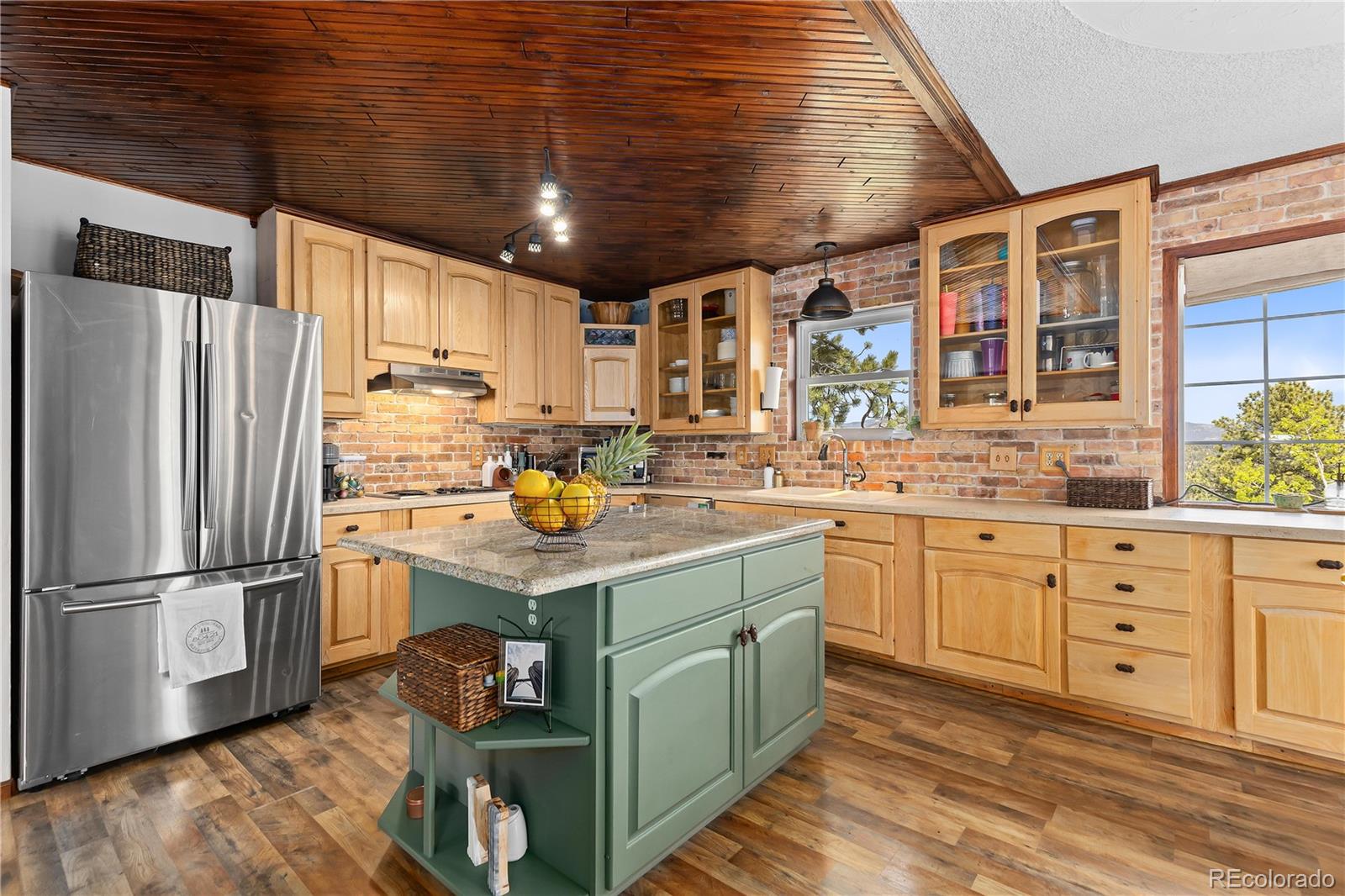 278 Overlook Drive Bailey, CO 80421 - Photo 11 of 37 a kitchen with stainless steel appliances kitchen island granite countertop a refrigerator a stove and white cabinets with wooden floors