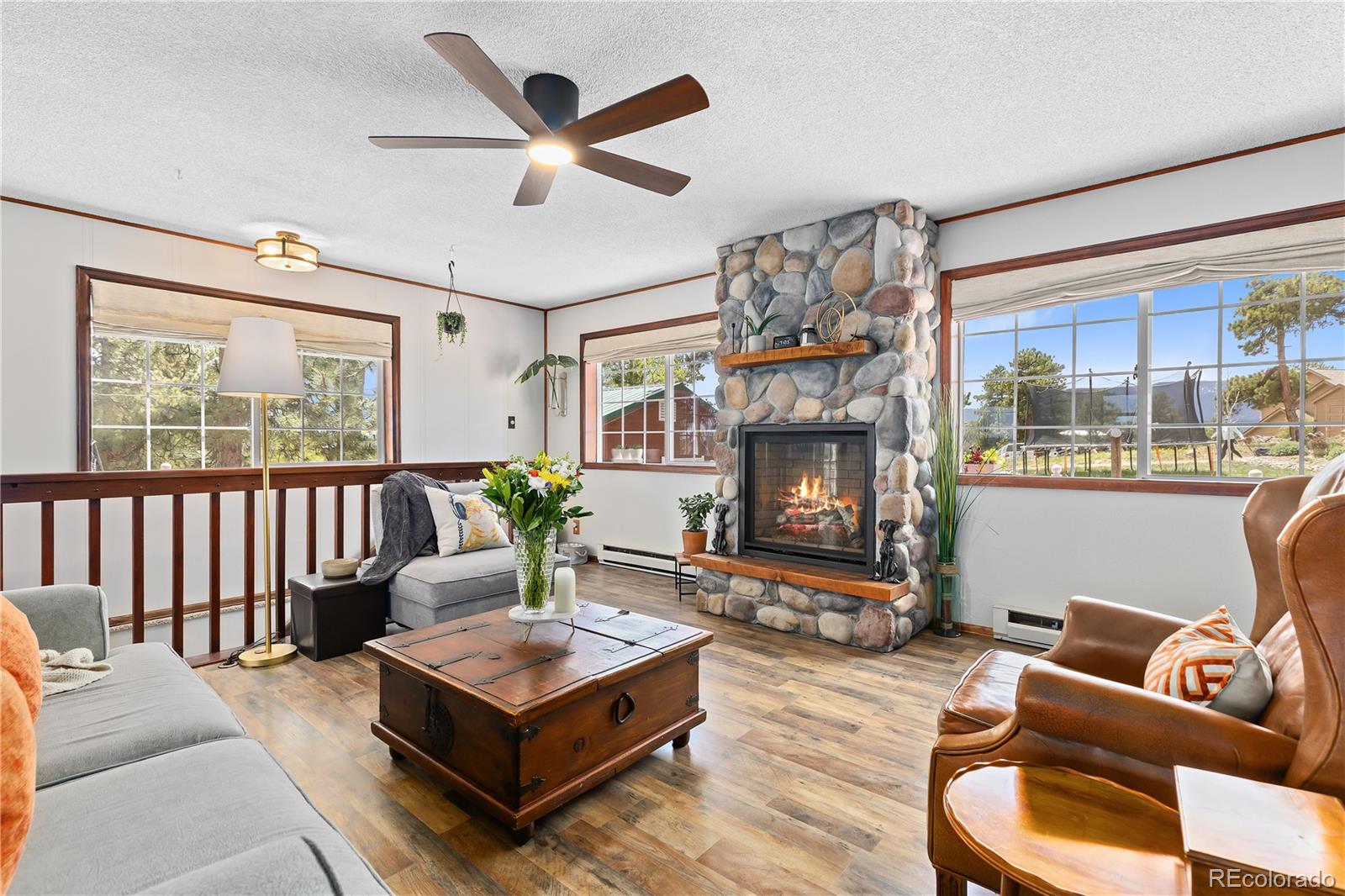 278 Overlook Drive Bailey, CO 80421 - Photo 3 of 37 a living room with furniture a large window and a fireplace