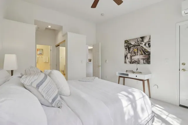 a bedroom with a bed and a lamp on dresser