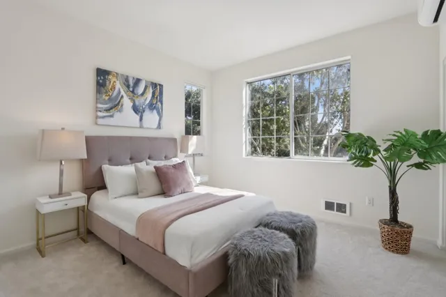 a bedroom with a bed and a potted plant