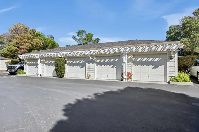a front view of a house with a yard and potted plants