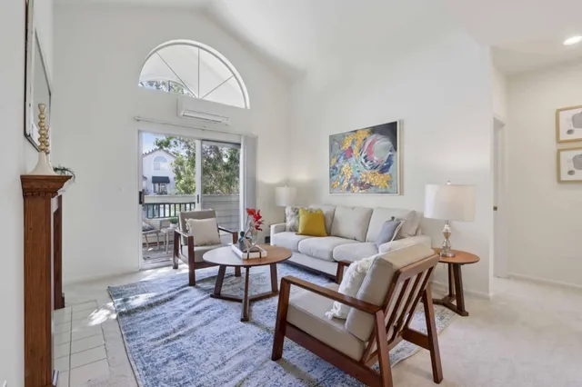 a living room with furniture a rug a lamp and a window