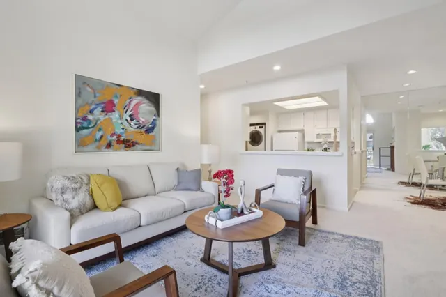 a living room with furniture and a dining table with wooden floor
