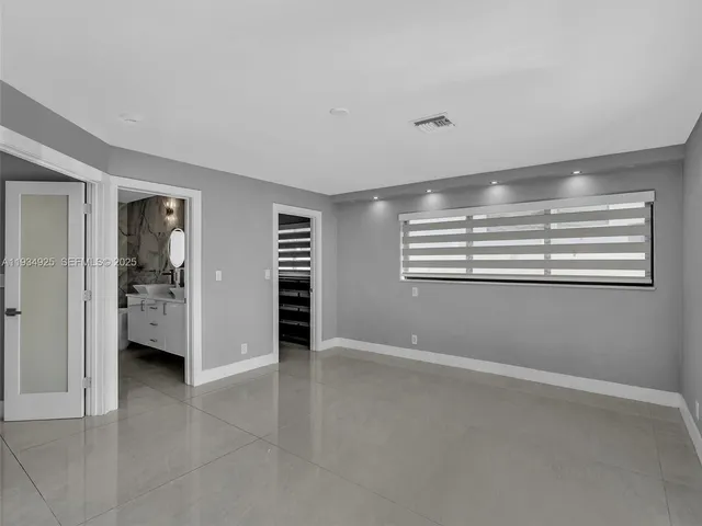 a view of an empty room with a cabinet and fire place