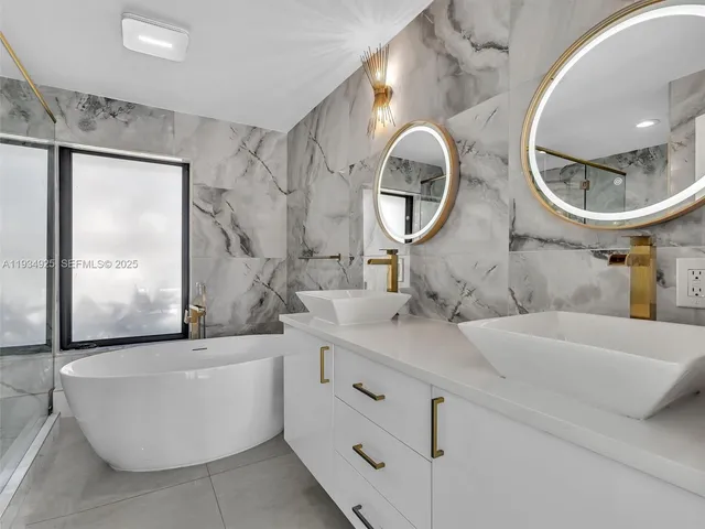 a bathroom with a double vanity sink mirror and bathtub