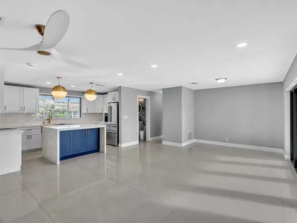 a large kitchen with stainless steel appliances a large counter top and cabinets