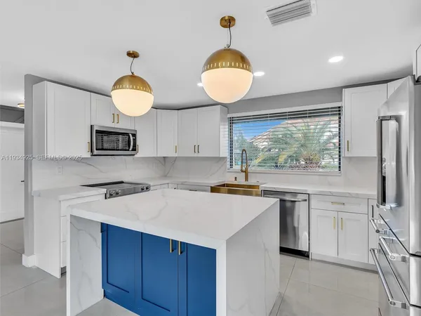 a kitchen with stainless steel appliances a stove a sink and a wooden floors