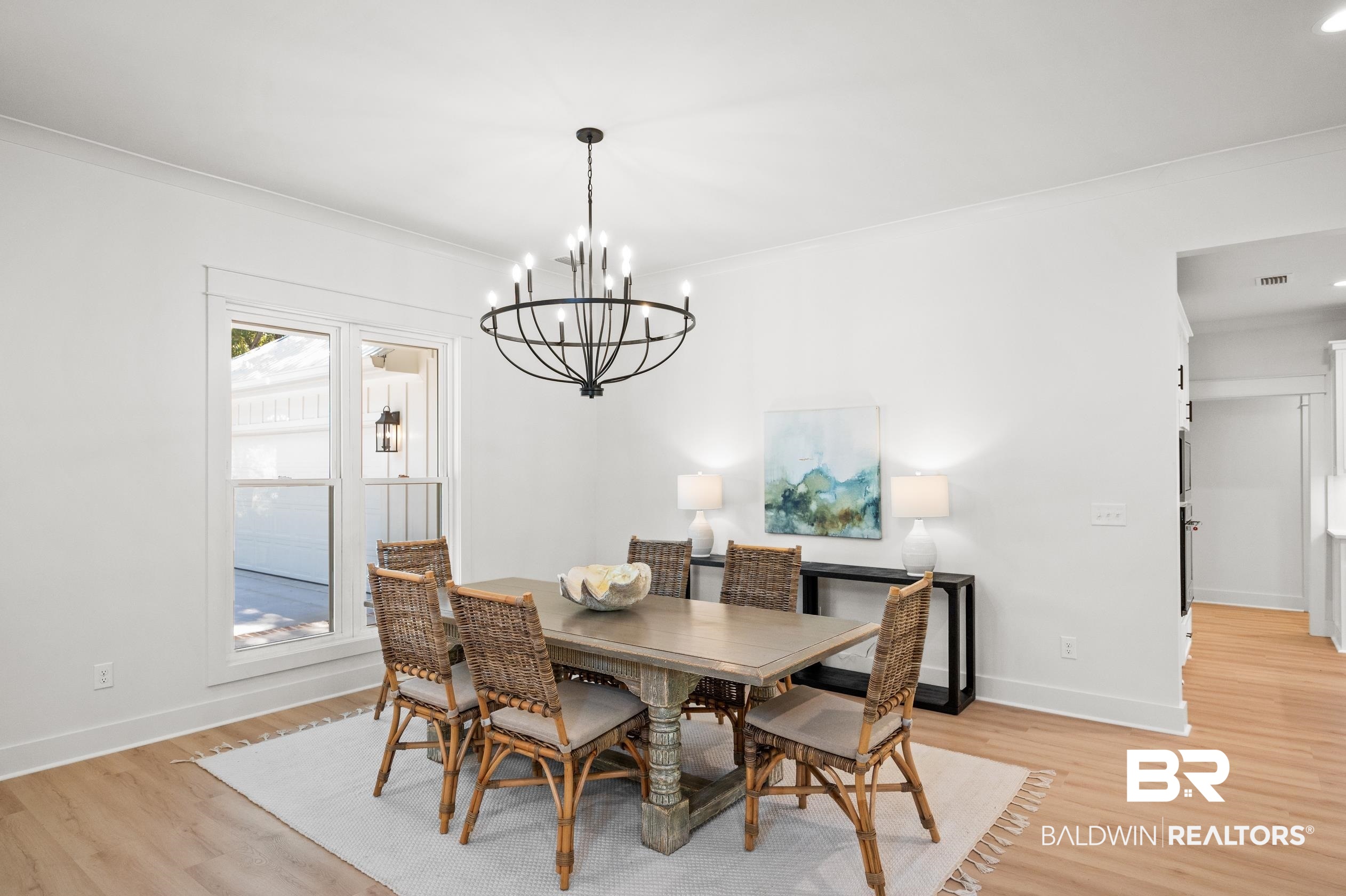 28889 Canal Road Orange Beach, AL 36561 - Photo 7 of 55 Dining area featuring ornamental molding, light wood-type flooring, and a notable chandelier