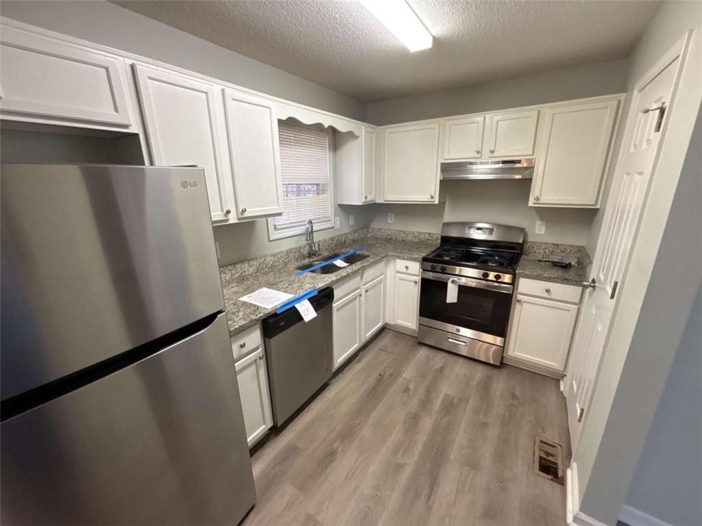 732 Newport Drive Villa Rica, GA 30180 - Photo 12 of 44 a kitchen with stainless steel appliances a refrigerator stove and sink