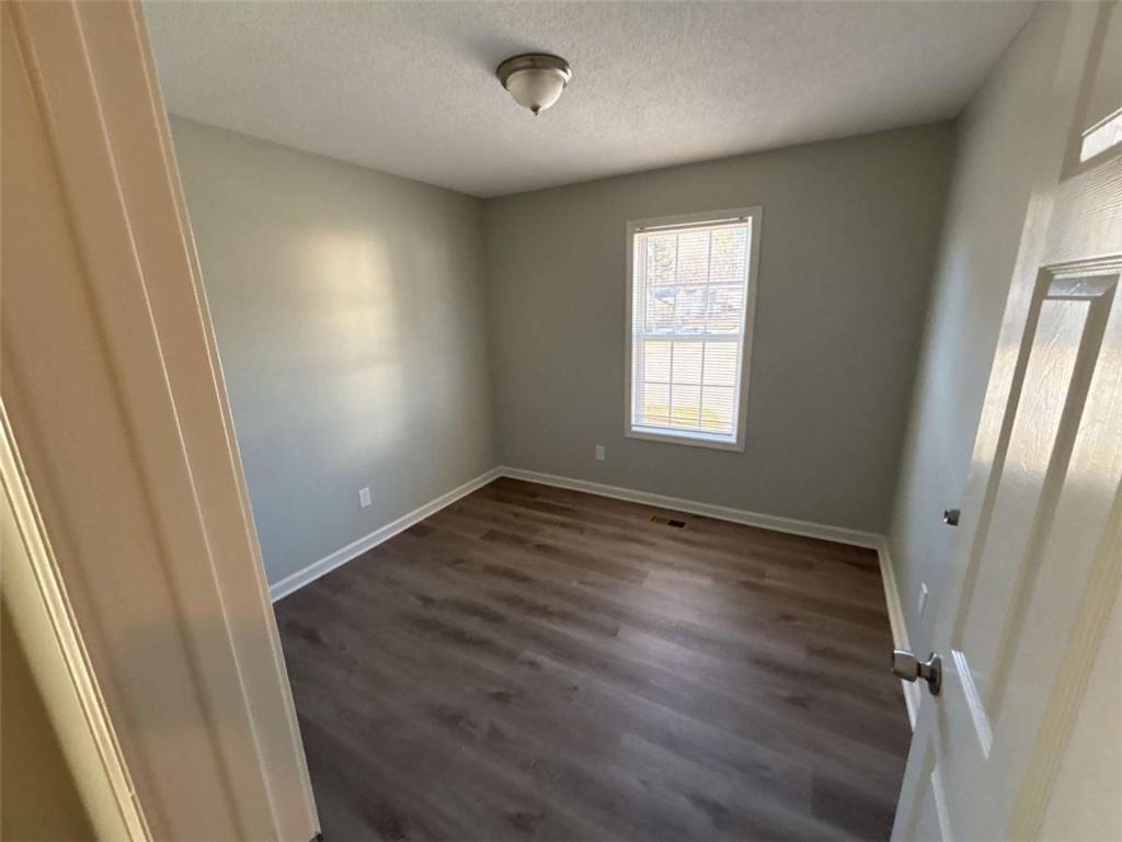 732 Newport Drive Villa Rica, GA 30180 - Photo 24 of 44 an empty room with wooden floor and window