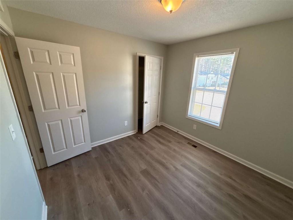 732 Newport Drive Villa Rica, GA 30180 - Photo 28 of 44 an empty room with wooden floor and windows