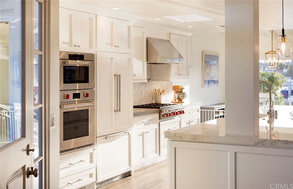 56 Balboa Newport Beach, CA 92663 - Photo 11 of 37 a kitchen with white cabinets and appliances
