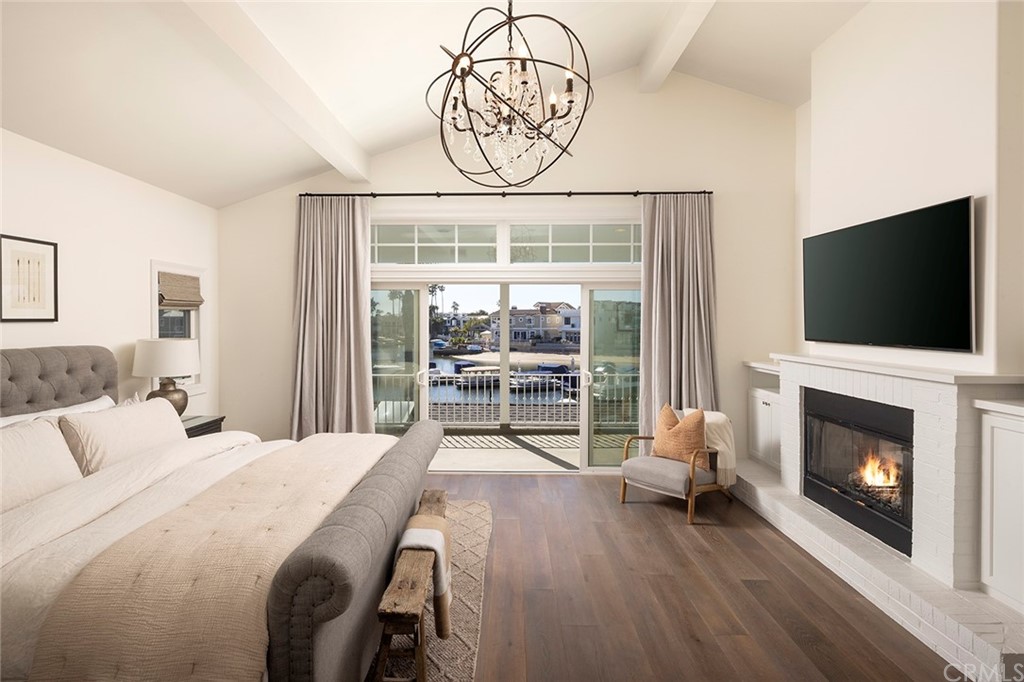 56 Balboa Newport Beach, CA 92663 - Photo 17 of 37 a bedroom with a bed a flat screen tv and a fireplace with the view
