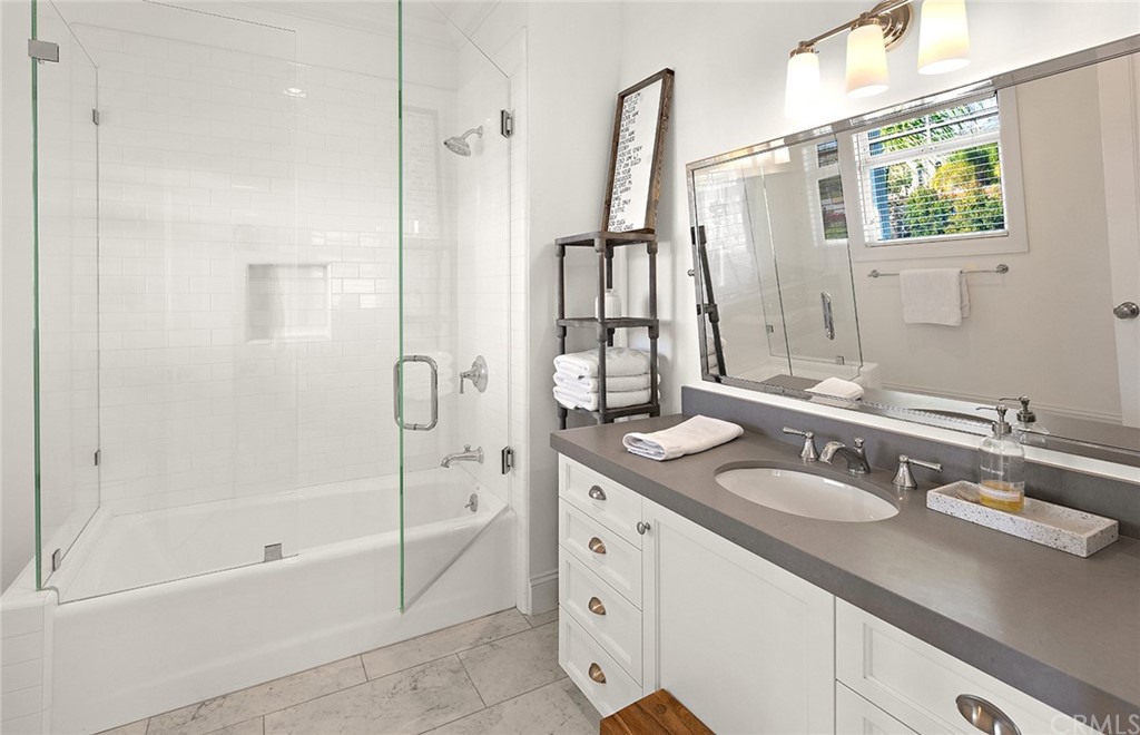 56 Balboa Newport Beach, CA 92663 - Photo 24 of 37 a bathroom with a granite countertop sink a mirror and a bathtub