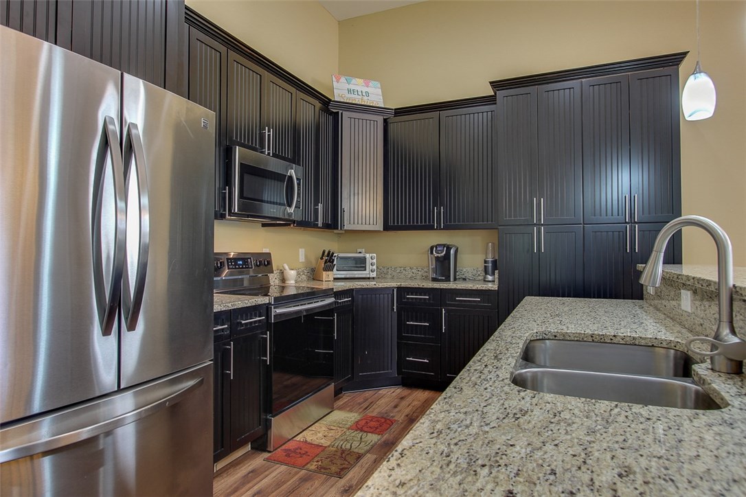 96155 Captains Pointe Road Yulee, FL 32097 - Photo 11 of 30 a kitchen with granite countertop a refrigerator and a sink