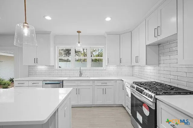 a kitchen with granite countertop white cabinets and white appliances