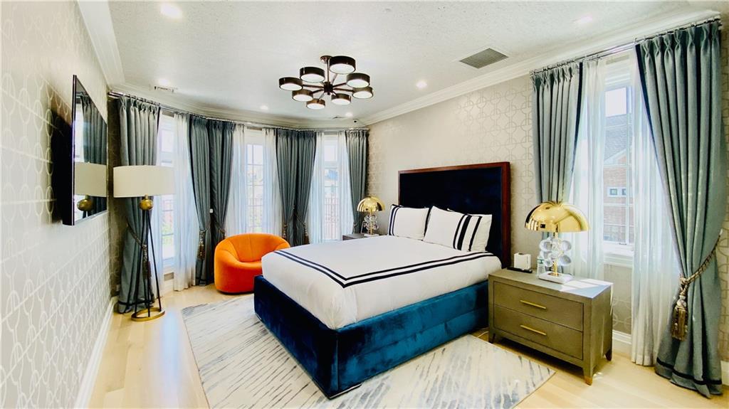 222 Exeter Street Brooklyn, NY 11235 - Photo 15 of 39 a bedroom with a bed and a flat tv screen on dresser