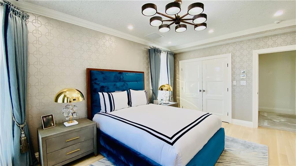222 Exeter Street Brooklyn, NY 11235 - Photo 16 of 39 a bedroom with a bed and a chandelier