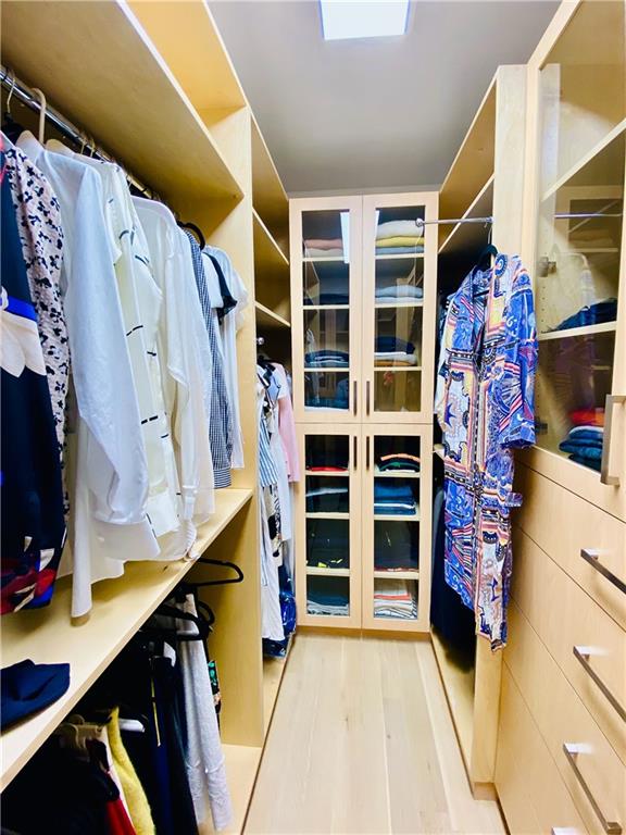 222 Exeter Street Brooklyn, NY 11235 - Photo 19 of 39 a view of walk in closet with clothes and shoes