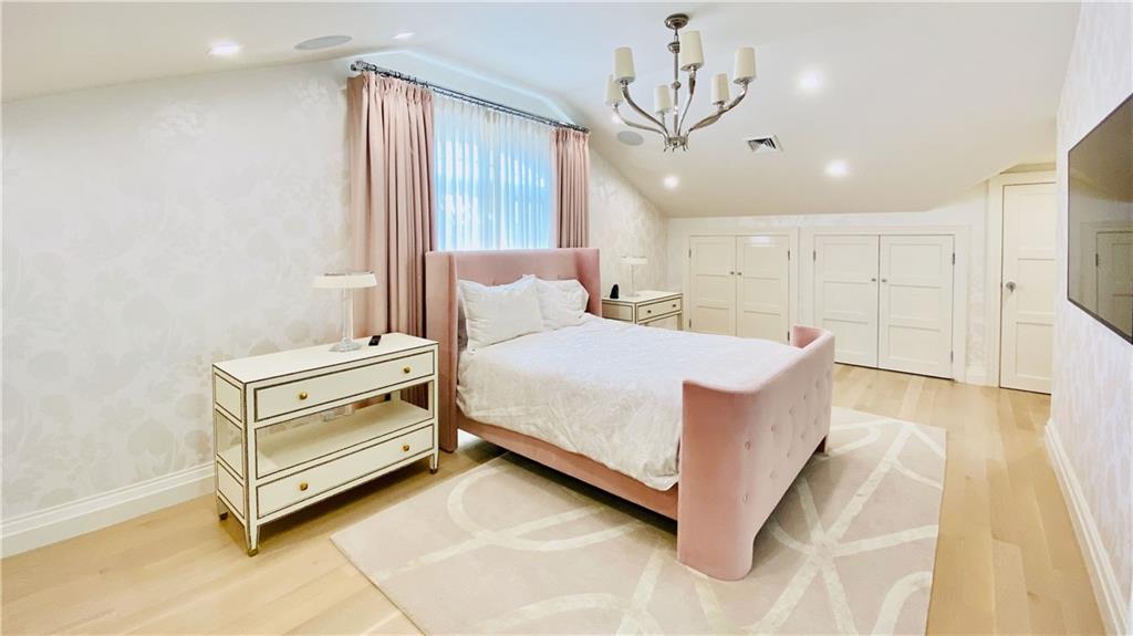 222 Exeter Street Brooklyn, NY 11235 - Photo 25 of 39 a bedroom with a bed and a chandelier