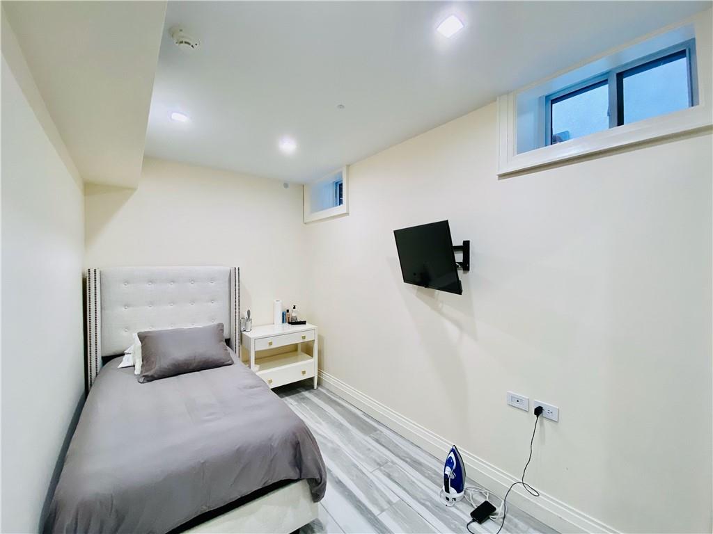 222 Exeter Street Brooklyn, NY 11235 - Photo 28 of 39 a bedroom with a bed and a flat screen tv