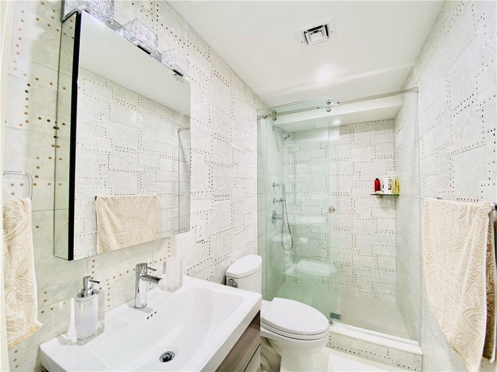 222 Exeter Street Brooklyn, NY 11235 - Photo 29 of 39 a bathroom with a sink a toilet and shower
