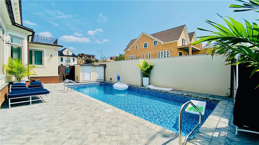 222 Exeter Street Brooklyn, NY 11235 - Photo 34 of 39 a swimming pool with barbeque oven table and chairs