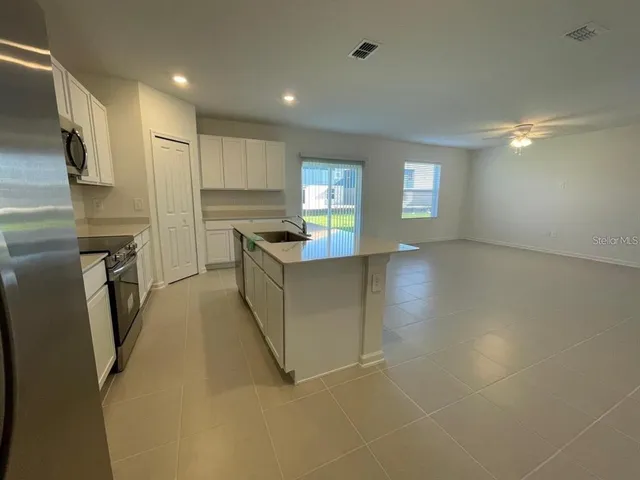 a view of a kitchen with refrigerator and windows