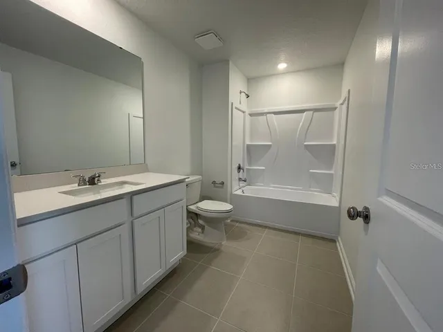 a bathroom with a double vanity sink toilet and shower