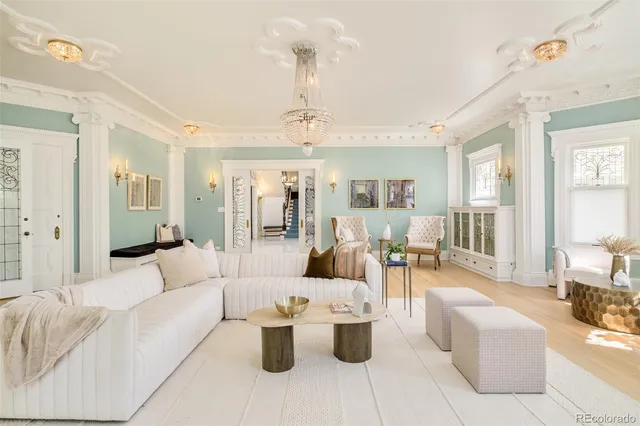 a living room with furniture a large window and potted plants