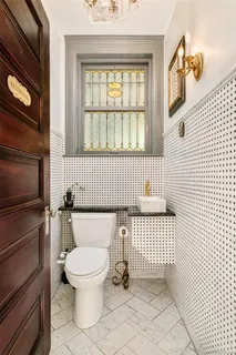 a dining room with wooden floor a chandelier a wooden table and chairs
