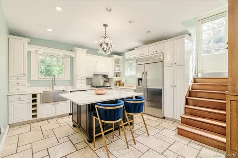 a view of living room kitchen with stainless steel appliances granite countertop sink and stove top oven