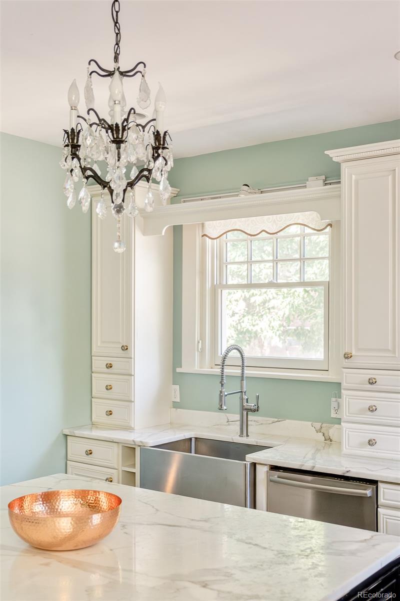680 North Clarkson Street Denver, CO 80218 - Photo 17 of 39 a kitchen with stainless steel appliances granite countertop a sink a window and chandelier