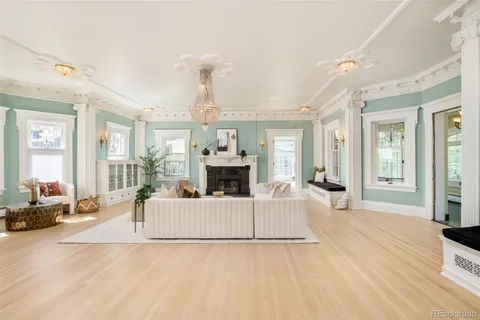 a living room with furniture a fireplace and a large window