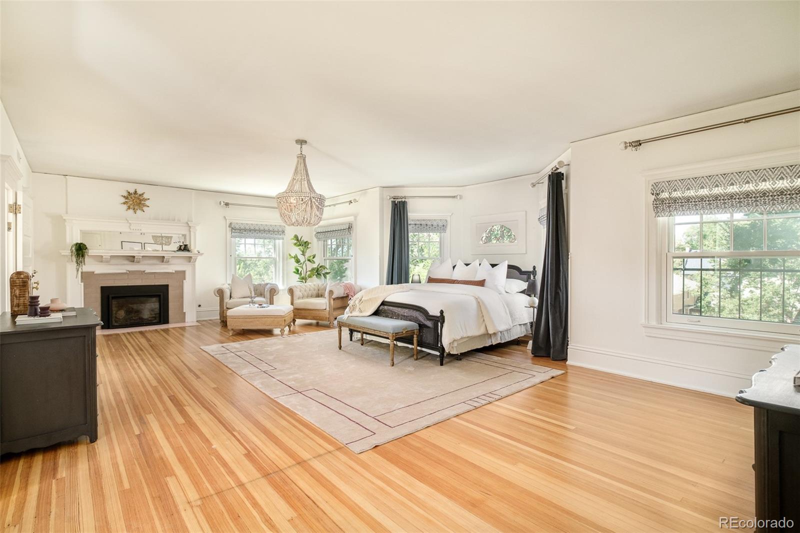 680 North Clarkson Street Denver, CO 80218 - Photo 21 of 39 a spacious bedroom with a bed and a fireplace