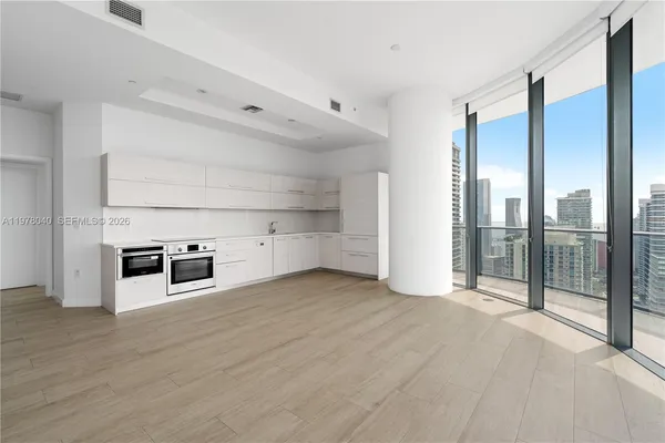 a view of a kitchen with stainless steel appliances a large window