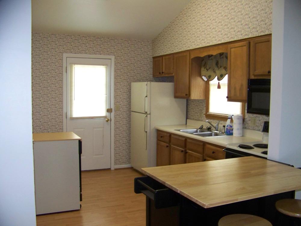 1422 Eanes Road Roanoke, VA 24014 - Photo 5 of 5 a kitchen with granite countertop a refrigerator a stove and white cabinets