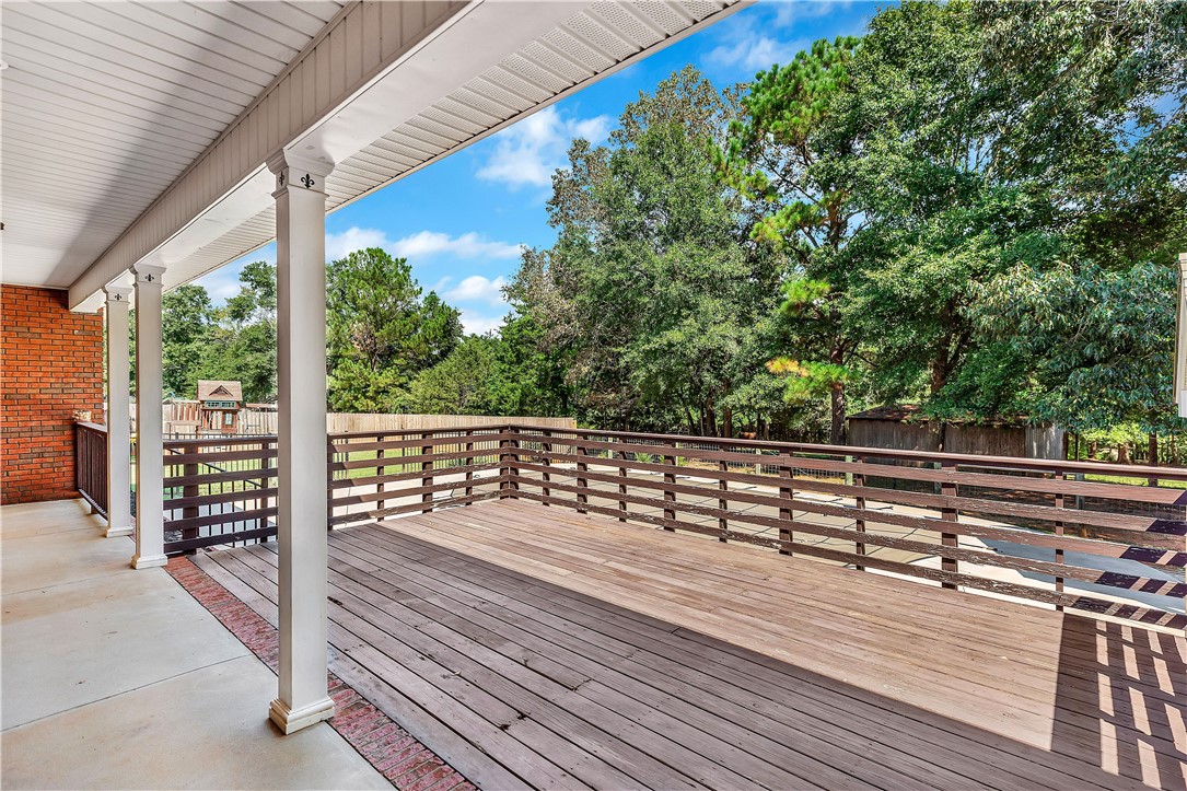 3620 Centerville Road Anderson, SC 29625 - Photo 9 of 49 An elevated wooden deck transitions to a covered porch overlooking a leafy backyard.